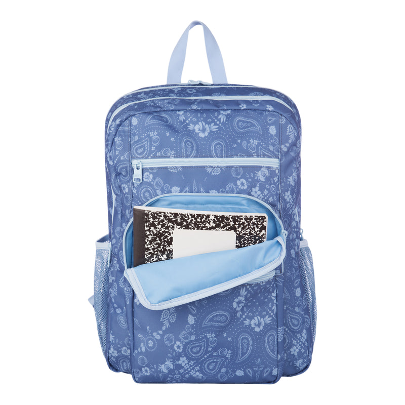 The Roxy Campus Crush Backpack features a blue paisley pattern and displays a black-and-white composition notebook inside its open front pocket. Crafted from recycled polyester, this backpack includes side mesh pockets, a top handle, organizer compartments for essentials, and a padded laptop sleeve—all showcased against a white background.