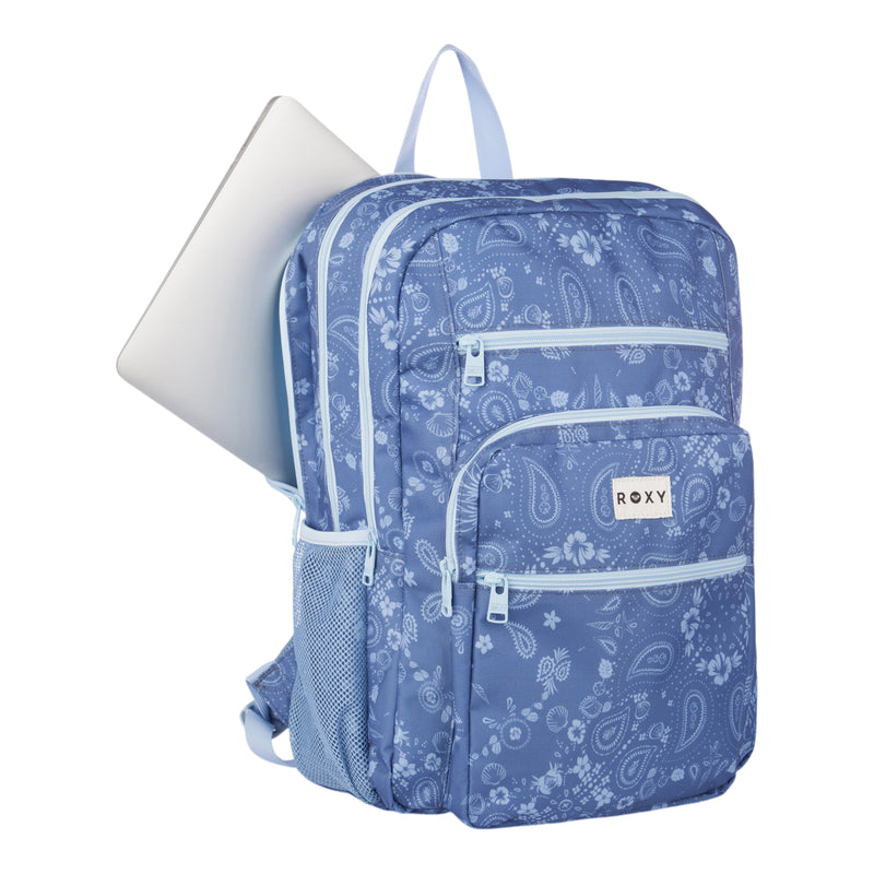 The Roxy Campus Crush Backpack, made from recycled polyester in a blue paisley pattern, has a laptop partially slid into the padded laptop sleeve inside its main compartment. The bag features several zippered pockets, convenient organizer pockets, light blue zippers, and a mesh side pocket.