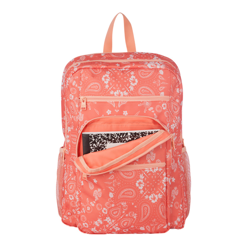 The Roxy Campus Crush Backpack in coral pink showcases white paisley patterns, with its front pocket unzipped to reveal a black and white composition notebook inside. Crafted from recycled polyester, this backpack offers side pockets, a top carrying loop, and convenient organizer pockets to keep your essentials neatly stored.