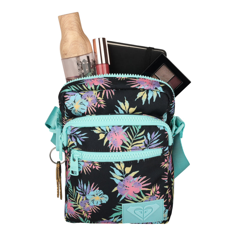 The Current Mood Crossbody Bag by Roxy, a small floral bag with aqua accents and echoes of the brand’s signature playful style, holds a wooden bottle, makeup, a palette, and keys—all displayed against a white background.