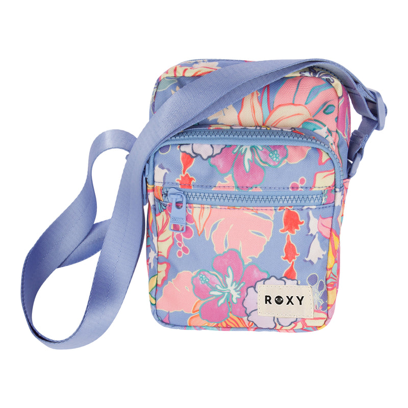 The ROXY Current Mood Crossbody Bag features a vibrant floral pattern in pink, orange, and purple hues. It comes with an adjustable blue strap, a front zipper pocket for easy access to essentials, and a white branded patch near the bottom.