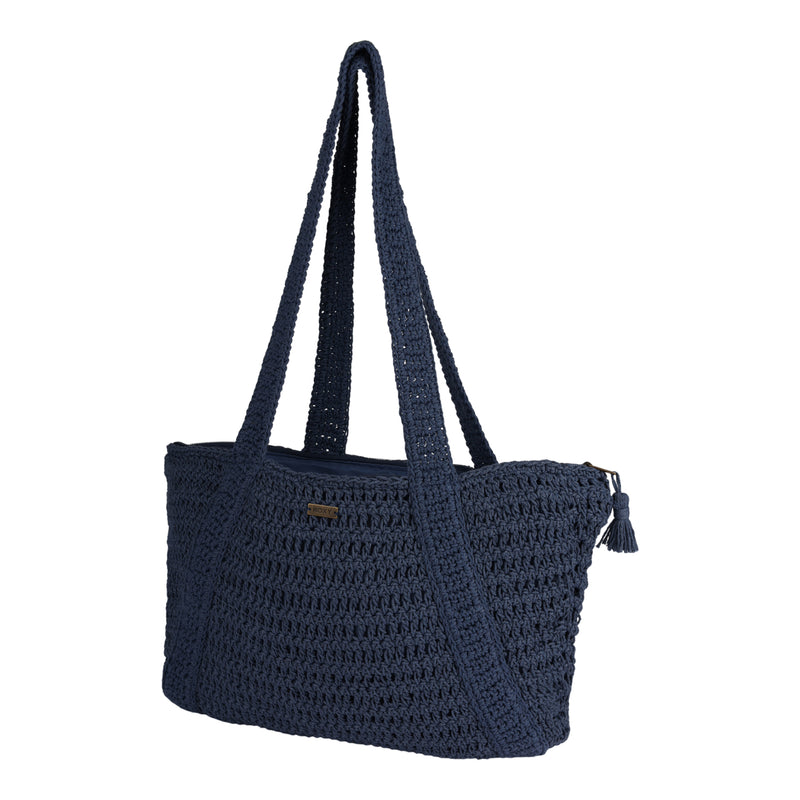 The Roxy Chips And Guac Tote Bag is a spacious, navy blue crocheted tote featuring a zippered top with a tassel, two long handles, and a rectangular shape—displayed against a white background.