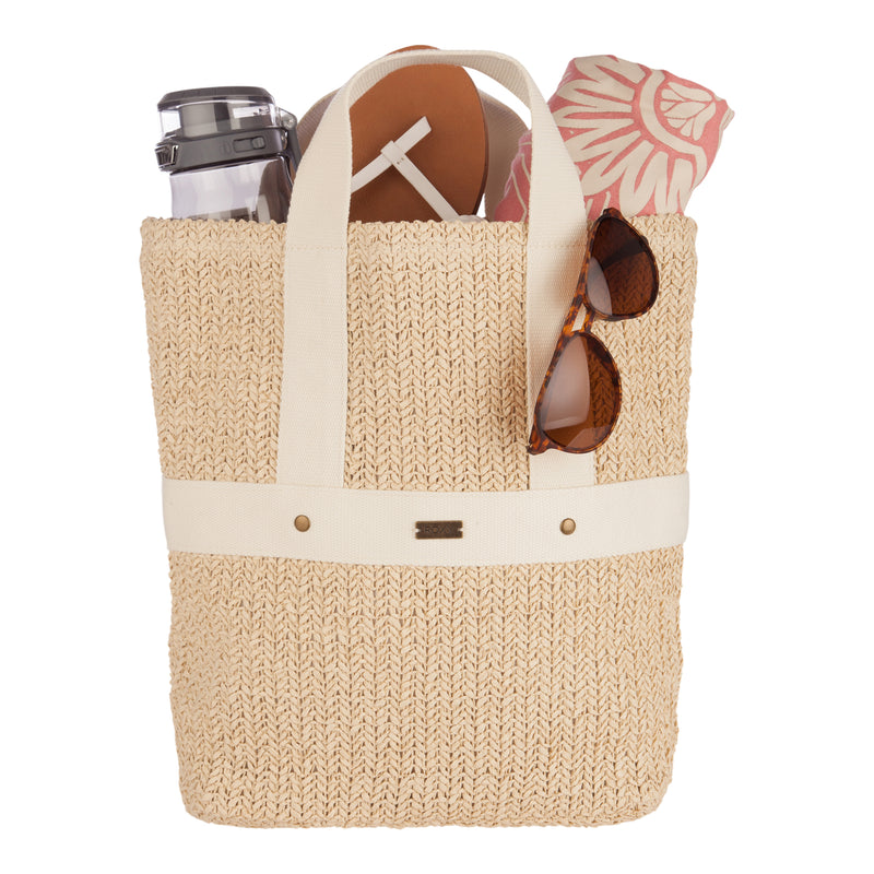 A woven straw tote bag holds a rolled towel, sandals, a water bottle, and sunglasses against a white background—the perfect scene for any beach day. For an alternative to the classic tote, consider swapping it out for the Roxy Sunny Stash Backpack for hands-free convenience and effortless beach vibes.