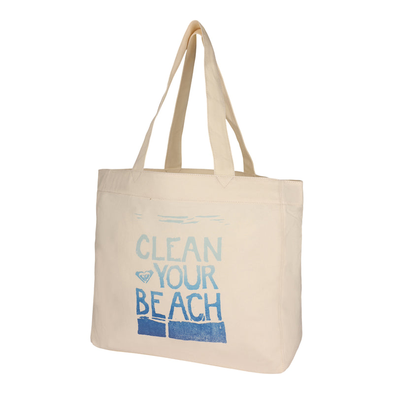 The ROXY Clean Your Beach Tote Bag is a beige, eco-friendly bag made from recycled cotton, featuring long handles and blue "CLEAN YOUR BEACH" text on the front. The tote bag is pictured empty and standing upright against a white background.