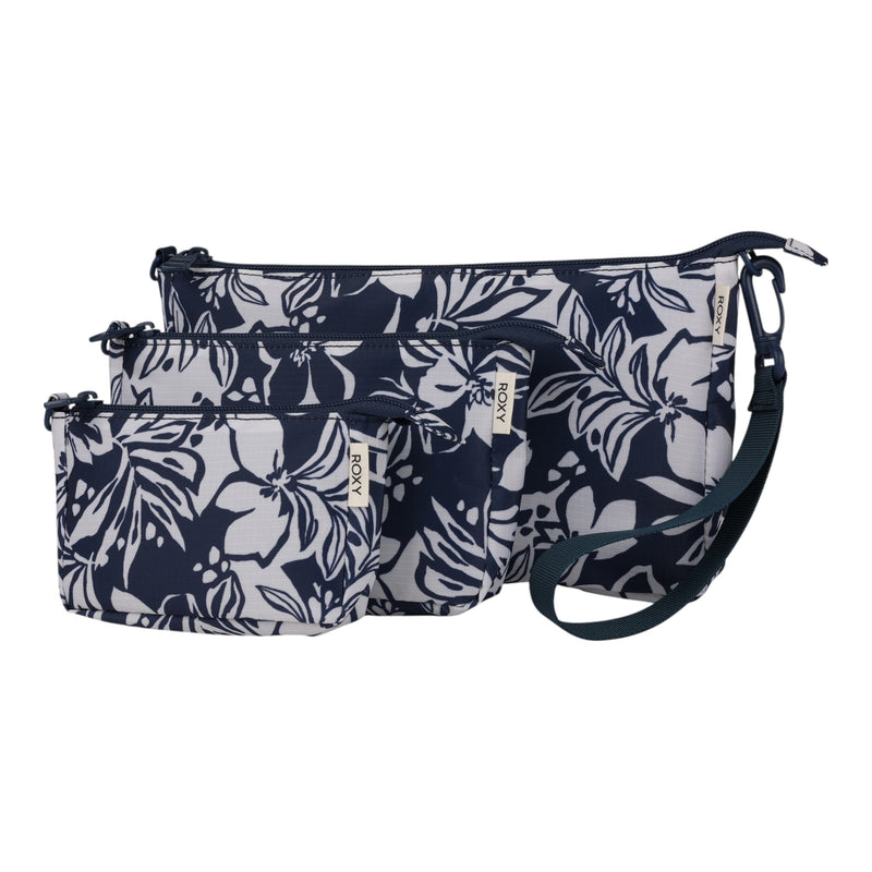 The Roxy Travel Pouch Set includes three zippered pouches in small, medium, and large sizes, each featuring a dark blue and white floral design, a detachable strap, and a small fabric tag—ideal for organized packing or carrying as a stylish crossbody pouch while on the go.