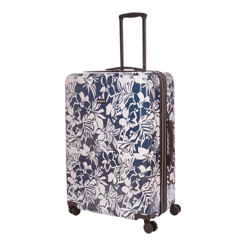 The Roxy Up And Away Hardside Spinner Large Luggage stands upright, showcasing a navy blue and white floral pattern. Designed with four smooth spinner wheels and an extended black telescopic handle, this suitcase combines stylish looks with reliable protection thanks to its durable PC/ABS shell.