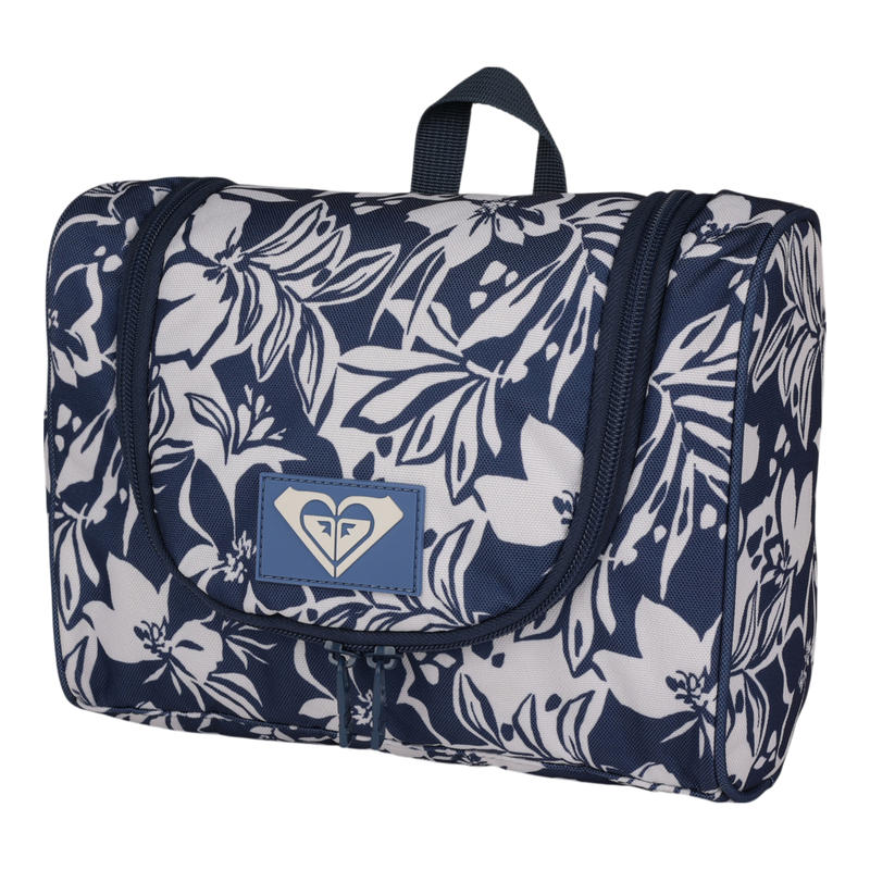 The Roxy Travel Dance Toiletry Kit is a blue and white floral-patterned hanging bag made from recycled polyester, featuring a zipper closure, a front flap adorned with the logo, and a small top handle—perfect for storing your travel essentials.