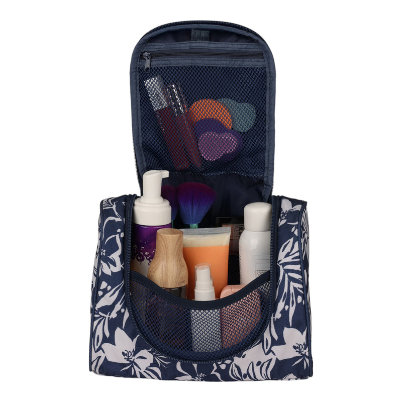 The Roxy Travel Dance Toiletry Kit, shown here in navy blue with a floral pattern, is open to display assorted toiletries and makeup items—including bottles, a brush, sponges, and tubes—tidily arranged within mesh pockets. Crafted from recycled polyester, this hanging travel storage bag offers sustainable convenience for all your journeys.