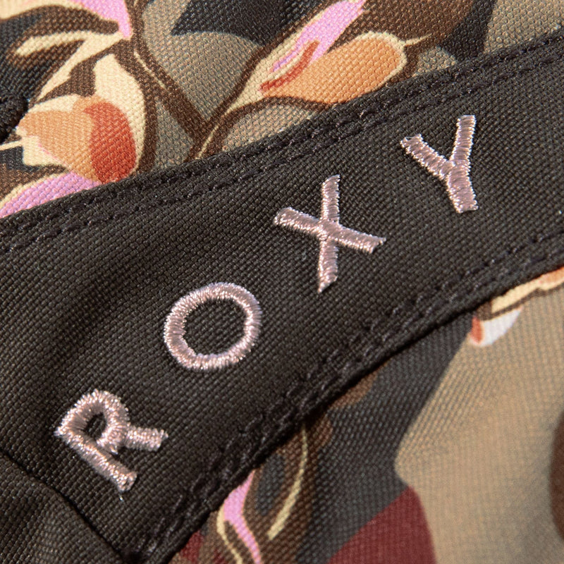 Close-up of a fabric with a floral pattern in muted colors. The brand name, Roxy, is embroidered in light pink thread on a black strip of the fabric, reminiscent of the signature detailing featured on the Roxy Jetty Gloves—waterproof gloves that combine style and functionality.
