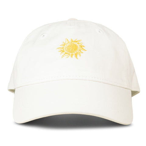 The Roxy Next Level Cap in Coconut Milk is a women’s baseball hat crafted from white cotton twill, with a yellow embroidered sun design on the front and a classic curved visor, shown against a plain white background.