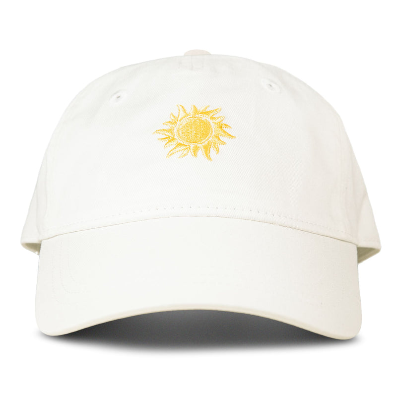 The Roxy Next Level Cap in Coconut Milk is a women’s baseball hat crafted from white cotton twill, with a yellow embroidered sun design on the front and a classic curved visor, shown against a plain white background.