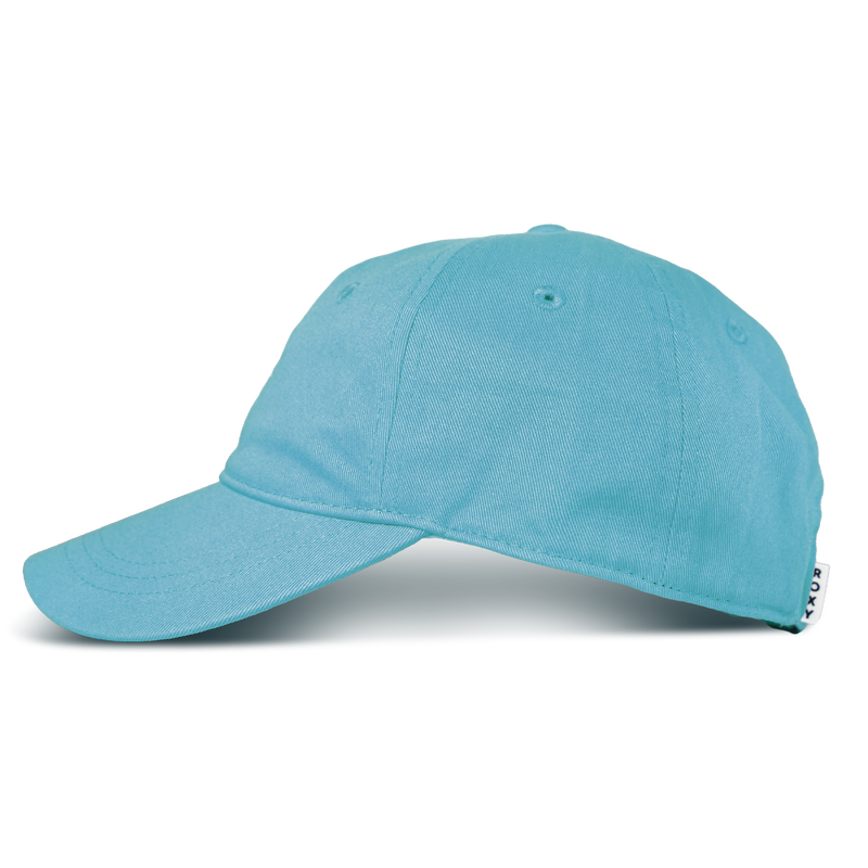 The Roxy Next Level Cap, a light blue women’s baseball hat made from soft cotton twill with a curved visor, is displayed from a side angle against a plain white background. A small white tag with black text is attached to the back.