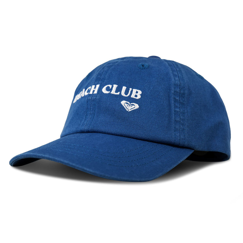A blue Roxy Toadstool Cap featuring “BEACH CLUB” embroidered in white across the front and a small heart-shaped logo beneath. The cap delivers a cool style and is displayed against a white background.