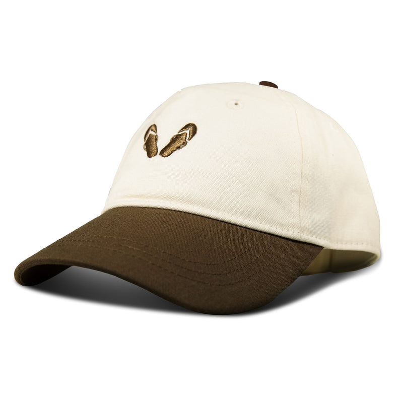 The Roxy Next Level Cap is a women’s baseball hat crafted from soft cotton twill in white, featuring a brown brim and curved visor, and finished with an embroidered pair of brown flip-flops on the front for a playful touch.
