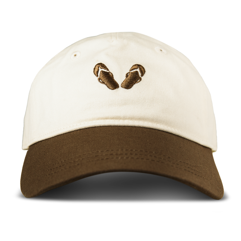 The Roxy Next Level Cap in Brownie/White is a women’s baseball hat featuring an embroidered design of two brown sandals on the front. Crafted from cotton twill, this cap offers a curved visor for comfortable, everyday style.