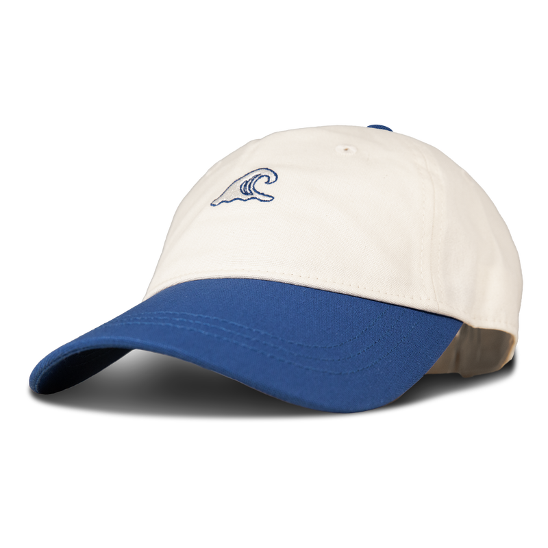 The Roxy Next Level Cap is a women’s baseball hat crafted from soft cotton twill in white, featuring a blue curved visor and a small blue wave logo embroidered on the front.