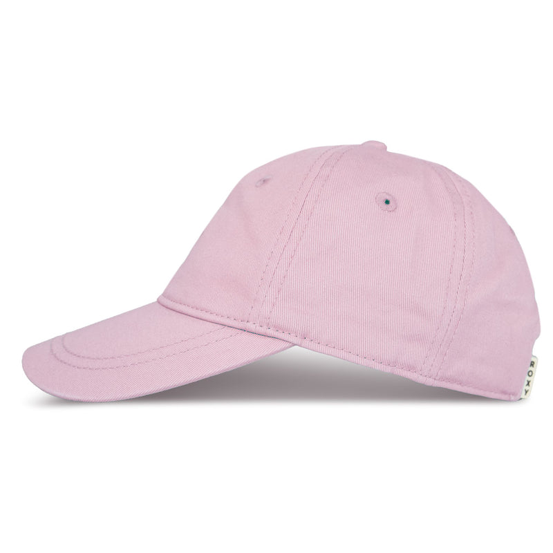 The TW Dear Believer Baseball Cap by Roxy is featured in a light pink shade, shown from the side with visible stitching and a small tag on the back. Designed with a curved brim and top ventilation holes, this cap is an ideal everyday accessory for casual outfits.