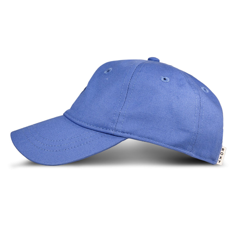 A side-view of the Roxy TW Dear Believer Baseball Cap is shown against a white background. This versatile blue cap, ideal for everyday wear, features a curved brim and a small white tag with text near the back.
