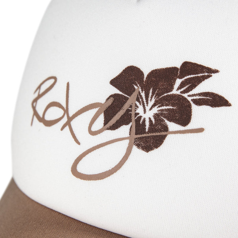 Close-up of a playful hat: the Donut Spain Trucker by Roxy—a white cap adorned with the brand’s name and a brown hibiscus flower graphic. The perfect casual accessory for everyday style.