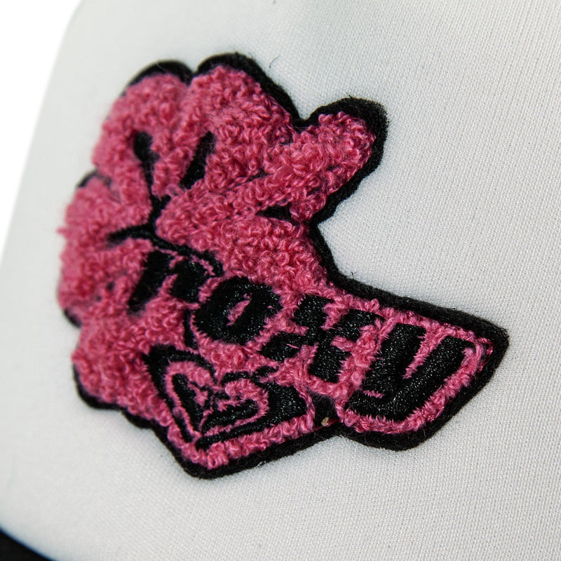 Close-up of a white fabric with a textured pink and black hibiscus patch, featuring an embroidered hand and the word “TOFU” above a heart—perfect for adding unique flair to your Roxy Island Ride Trucker hat with its adjustable snapback.