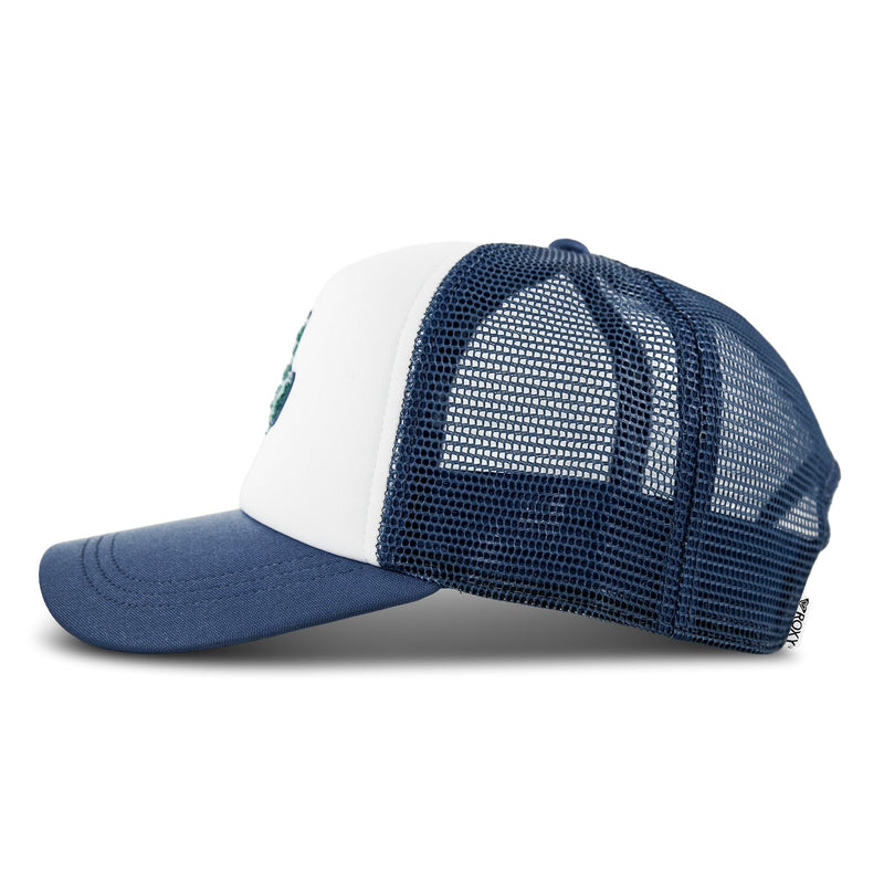 Side view of the Roxy Island Ride Trucker hat, featuring a solid blue curved brim, a white front panel, and a dark blue mesh back. A small Roxy brand tag accents the bottom edge, while a subtle hibiscus patch on the front adds beach-inspired flair. The cap is displayed against a plain white background.