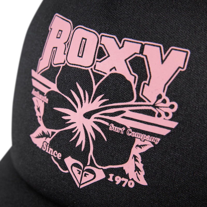 Close-up of the Roxy Sandy Top Trucker, a black fabric trucker cap featuring a pink hibiscus flower and “ROXY” above it. The text “Australia Surf Company Since 1970” is written in pink, with a small heart-shaped logo underneath. This adjustable snapback from Roxy offers comfortable sun protection—ideal for your beach days.