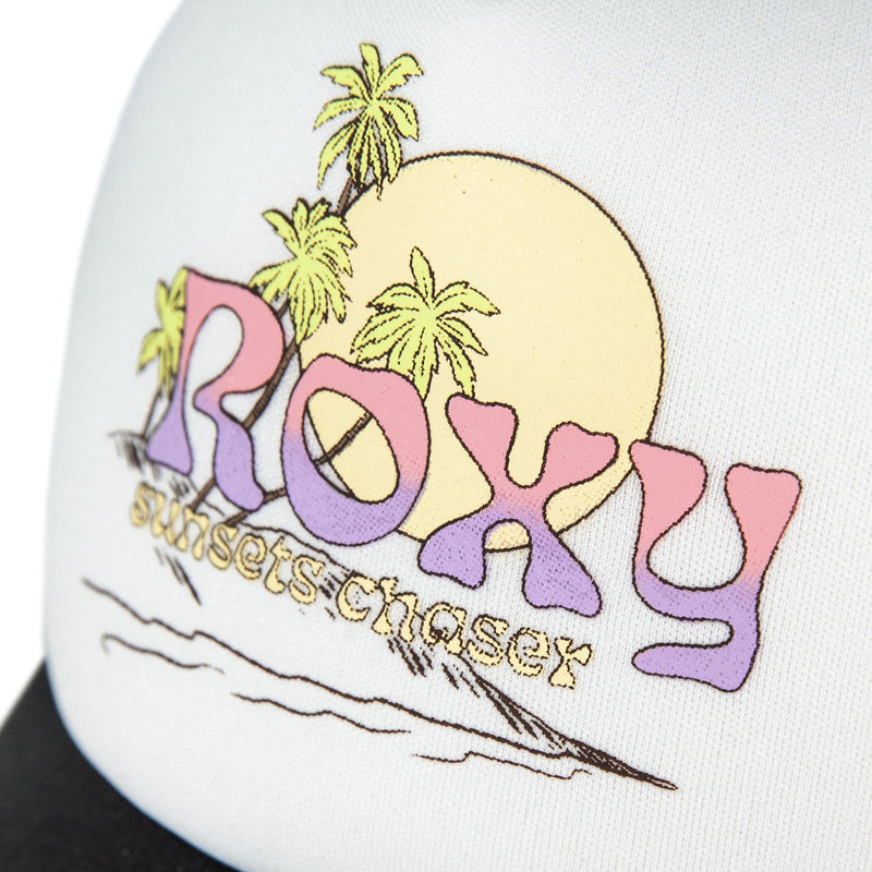 A close-up of the Roxy Sandy Top Trucker cap showcases a tropical design with palm trees, a sunset, and colorful ROXY lettering above the phrase “sunsets chaser.” This adjustable snapback combines stylish sun protection with vibrant beach vibes.