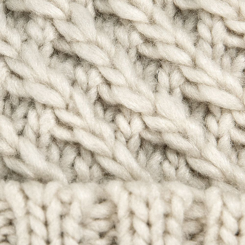 Close-up of a beige Roxy Blizzard Beanie, featuring a chunky knit with a textured diagonal cable pattern above a ribbed brim.