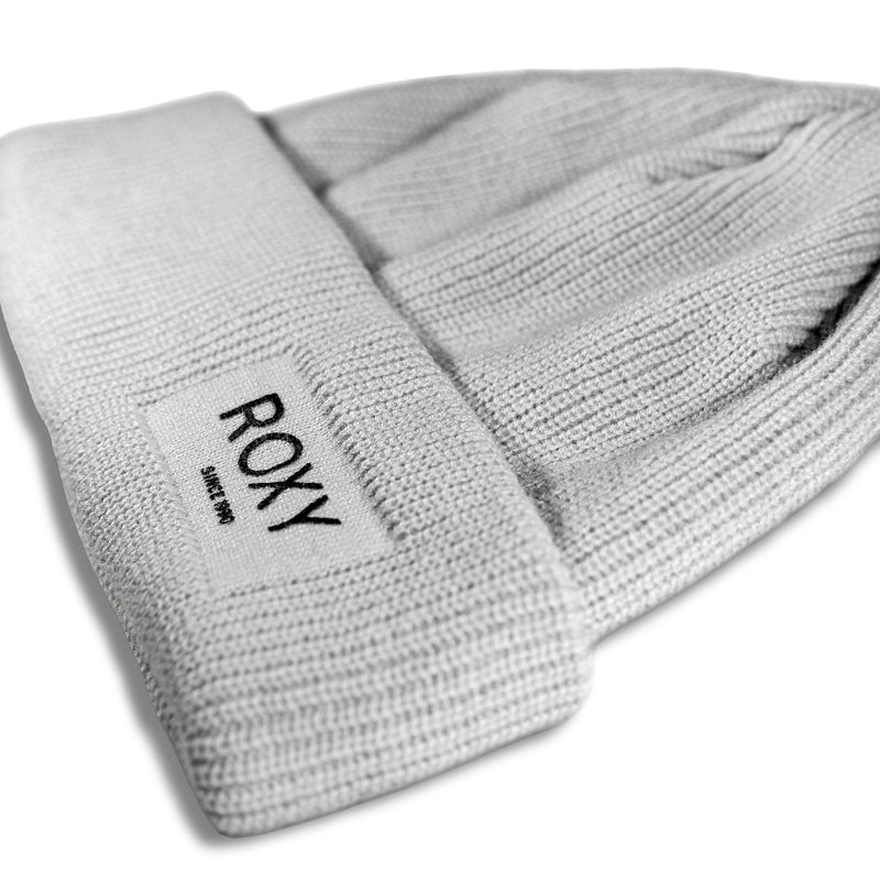 A light-colored Roxy Folker Beanie with a folded cuff featuring a rectangular patch that reads ROXY SINCE 1990.