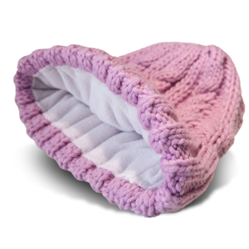 The Roxy Tram Beanie, a pink knitted hat made with thick yarn, features a soft white fleece lining inside. This cozy women’s beanie is shown on its side to highlight the interior texture and material.