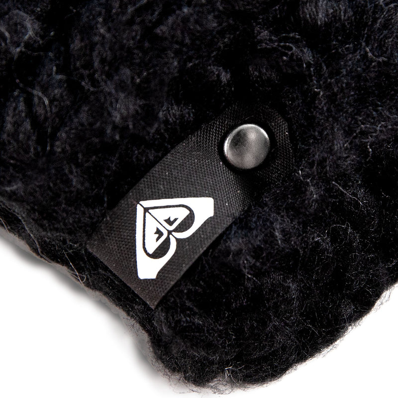 A close-up of the black textured fabric of the Roxy Winter Beanie showcases its cozy fleece lining, a black tag with a white heart-shaped logo, and a metal snap button.