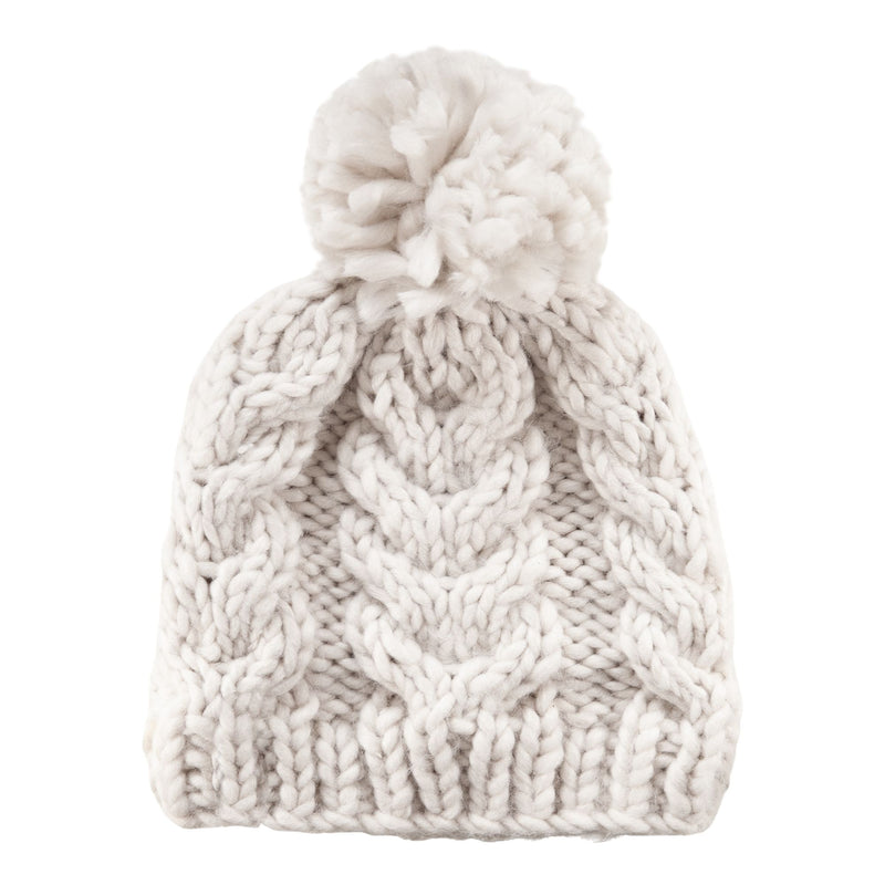 The Roxy Winter Beanie is a chunky knit women’s hat in white, featuring a ribbed edge, cable knit pattern, and a large pom-pom on top, shown against a white background.