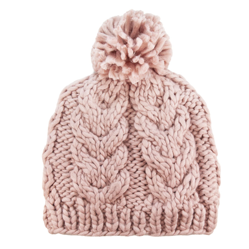 The Roxy Winter Beanie is a chunky knit pink hat with a classic cable knit pattern and a playful pom-pom on top, featuring a cozy fleece lining and shown against a white background.