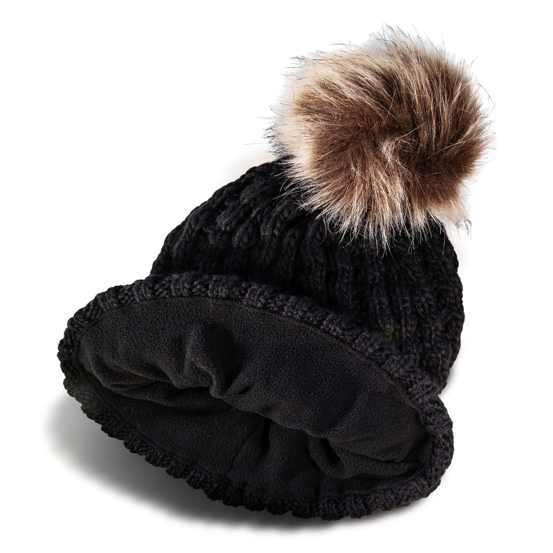 The Roxy Girls Blizzard Girl Beanie by Roxy is a black cable knit winter hat featuring a wide polar fleece lining and topped with a large, fluffy brown faux fur pom-pom, displayed on a white background.