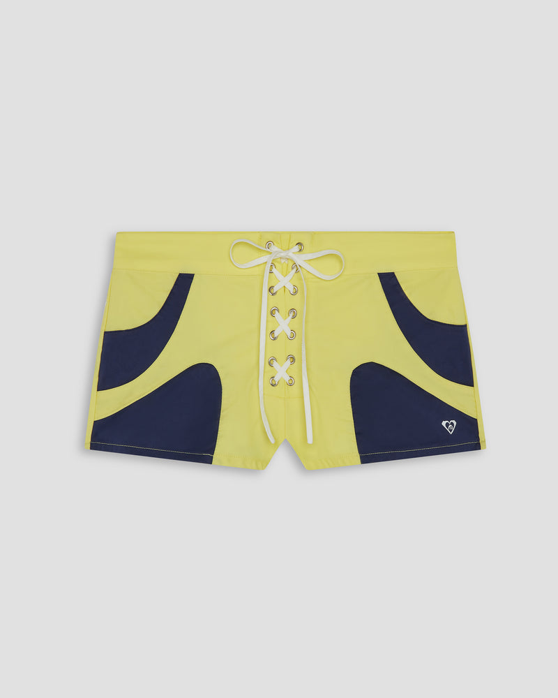 Beach-ready Blake Shorts by Roxy in yellow feature lightweight nylon, navy curved panels, a white lace-up center closure, and a small white logo near the left hem.