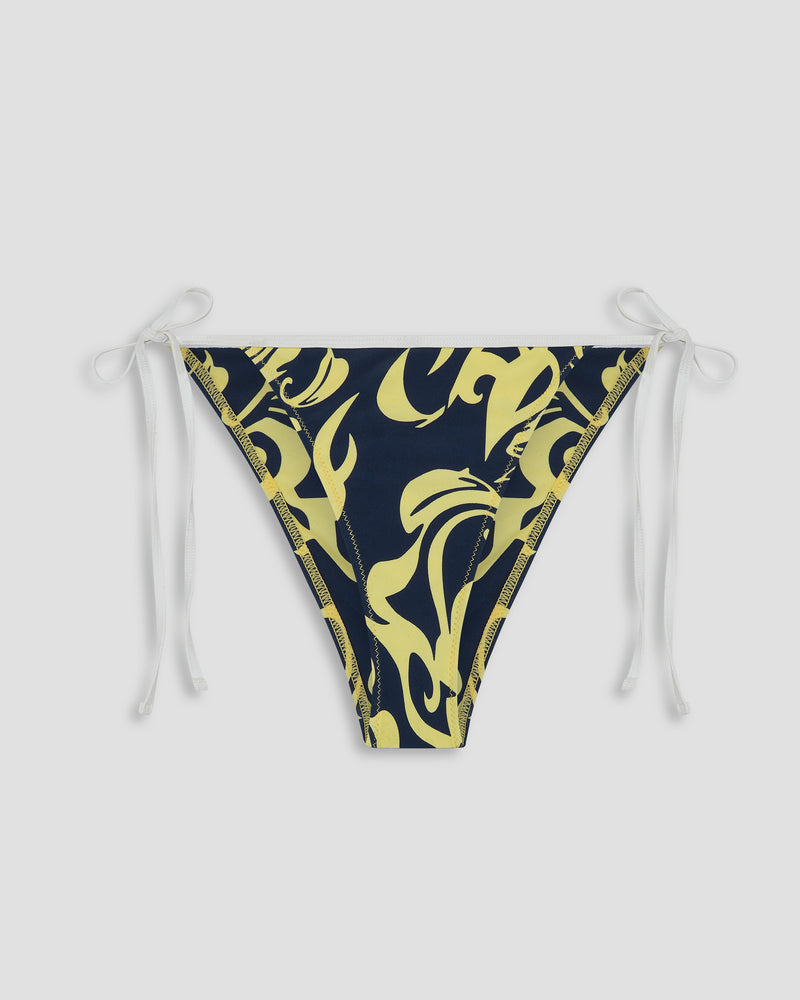 The Roxy Kauai Bikini Bottom features a navy blue Hawaiian print with bold yellow abstract patterns and white adjustable string-tie sides, displayed on a plain white background.