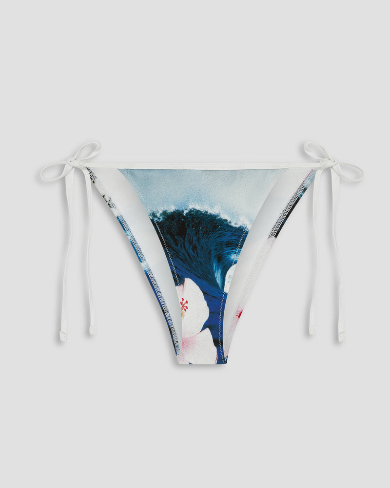 The Roxy Kauai Bikini Bottom features an adjustable white string-tie design and showcases a blue wave print with a pink and white hibiscus flower on the front, set against a plain light background.