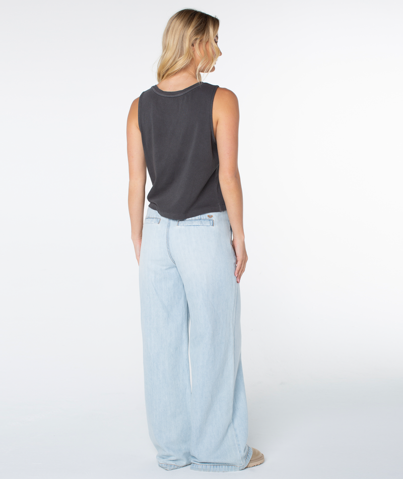 A person seen from behind wearing a charcoal gray cotton blend Palm Tree Resort Wildflower Tank and light-wash wide-leg jeans.
