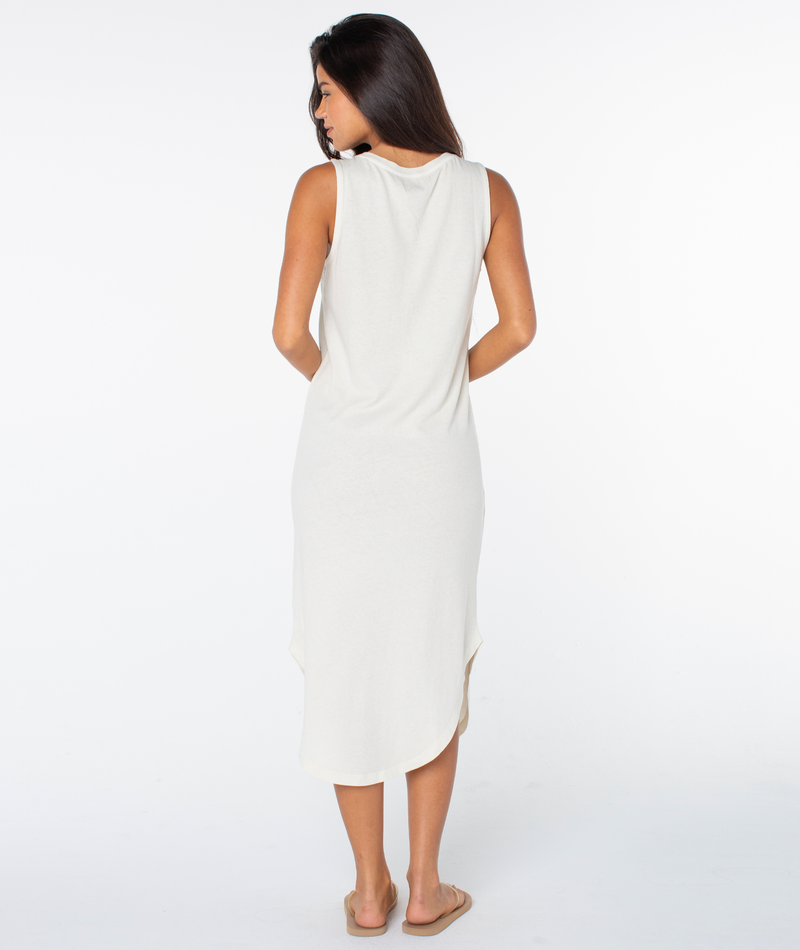 A woman with long dark hair faces away, wearing the Roxy Made In The Sun Wildflower Midi Dress and beige sandals, set against a plain white background.