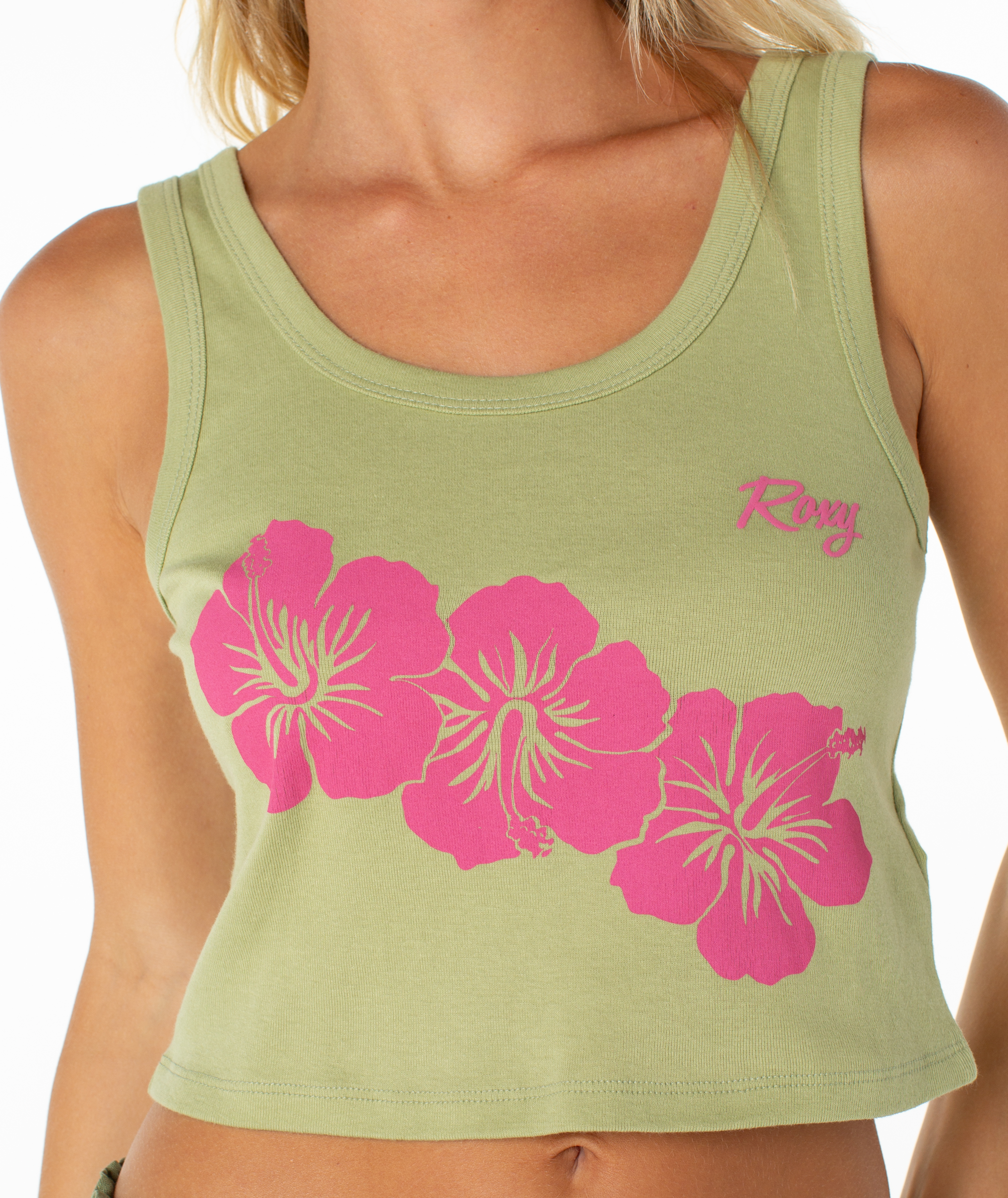The Roxy Scoop Baby Rib Tank is a light green, cropped cotton tank featuring a pink hibiscus floral print and the Roxy logo.