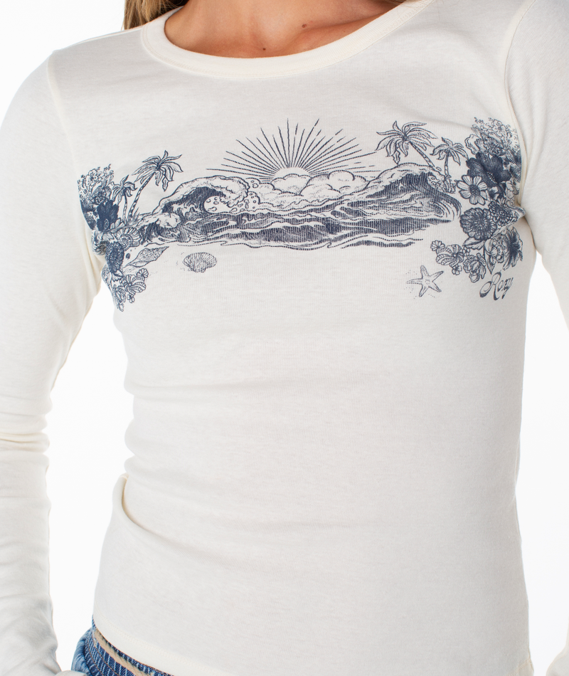 Roxy On Holiday Baby Rib Long Sleeve Top in cream, featuring a blue vintage-style graphic of a sunset, ocean waves, palm trees, and flowers across the chest.