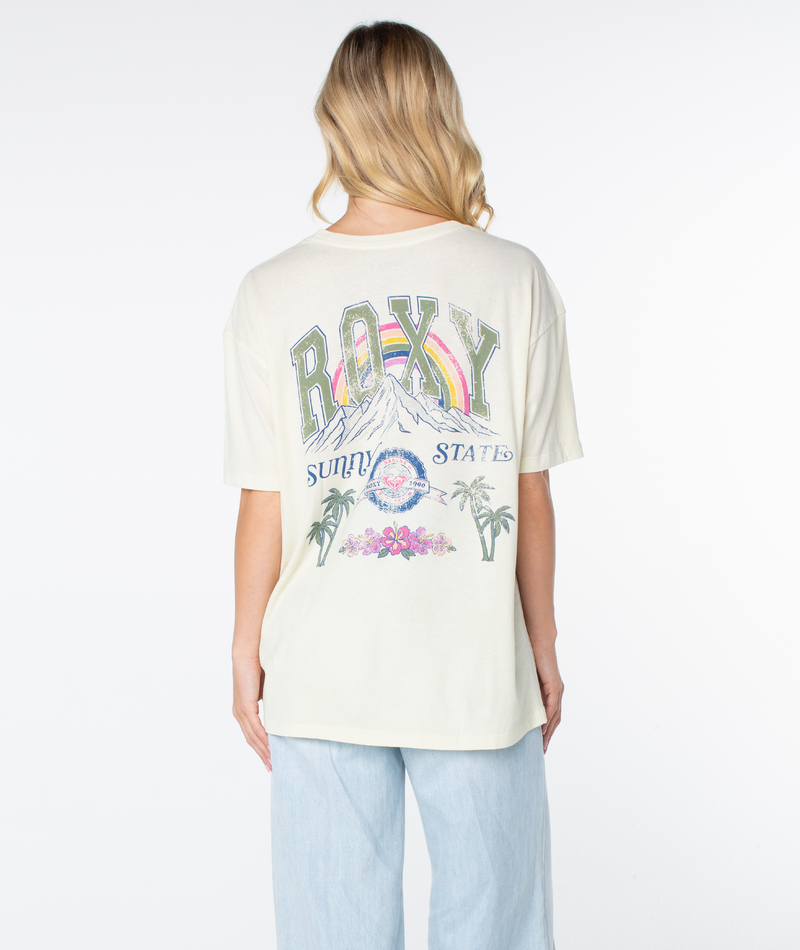 Back view of an oversized cream Roxy Sunny State Tee featuring a vintage-style graphic with a rainbow, mountains, palm trees, and the text Roxy Sunny State.