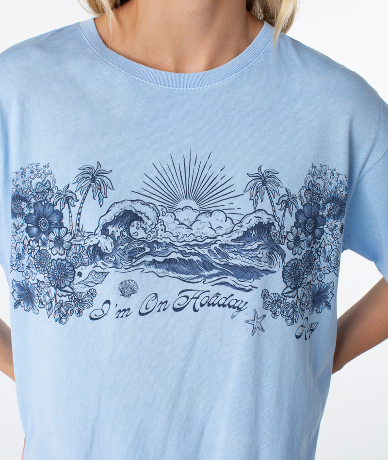 Roxy On Holiday Top: light blue oversized tee featuring a dark blue graphic of ocean waves, palm trees, flowers, and the text Im On Holiday.