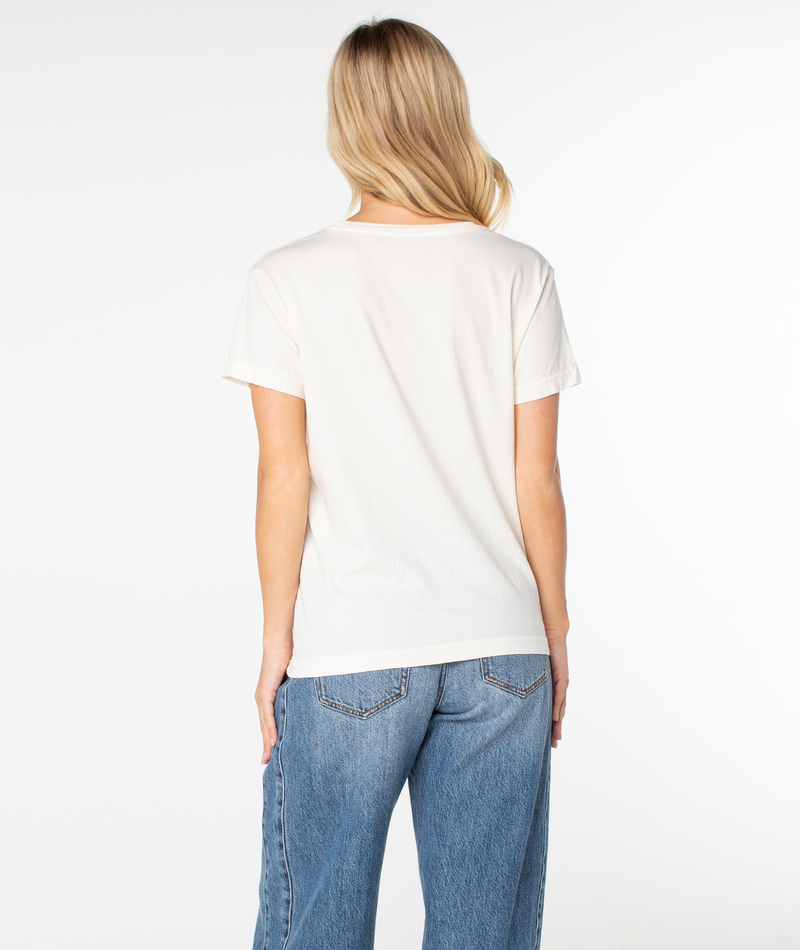 Back view of a person wearing a slouchy, plain white Dad Vibes Surfboard Tee and blue jeans.