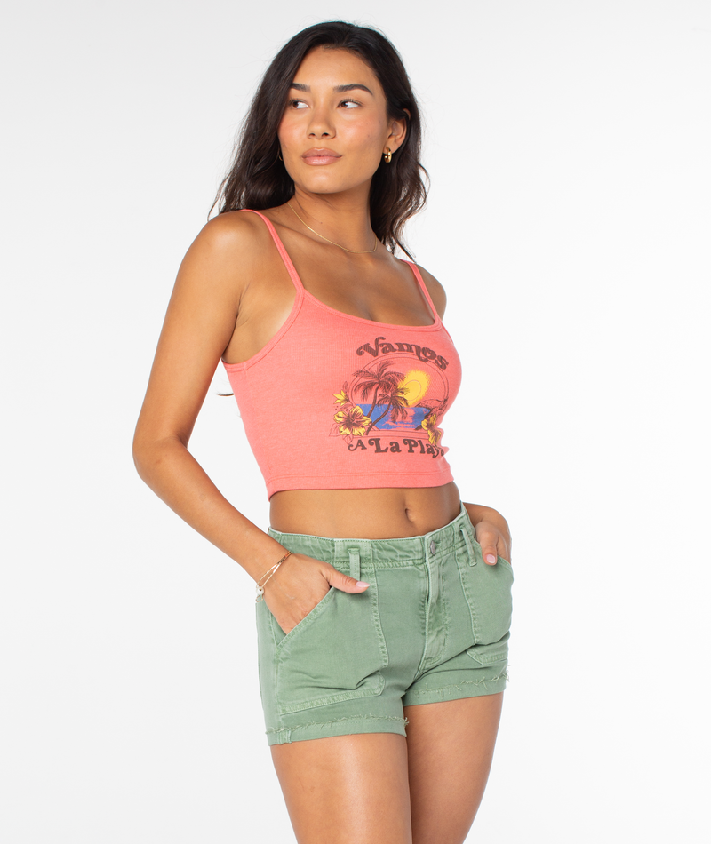 A model wears a coral Roxy Vamos Tee with spaghetti straps and a tropical graphic paired with olive green shorts.
