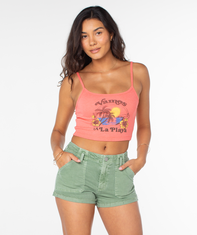 A coral-colored Roxy Vamos Tee cropped tank top with a beach graphic worn with olive green denim shorts.