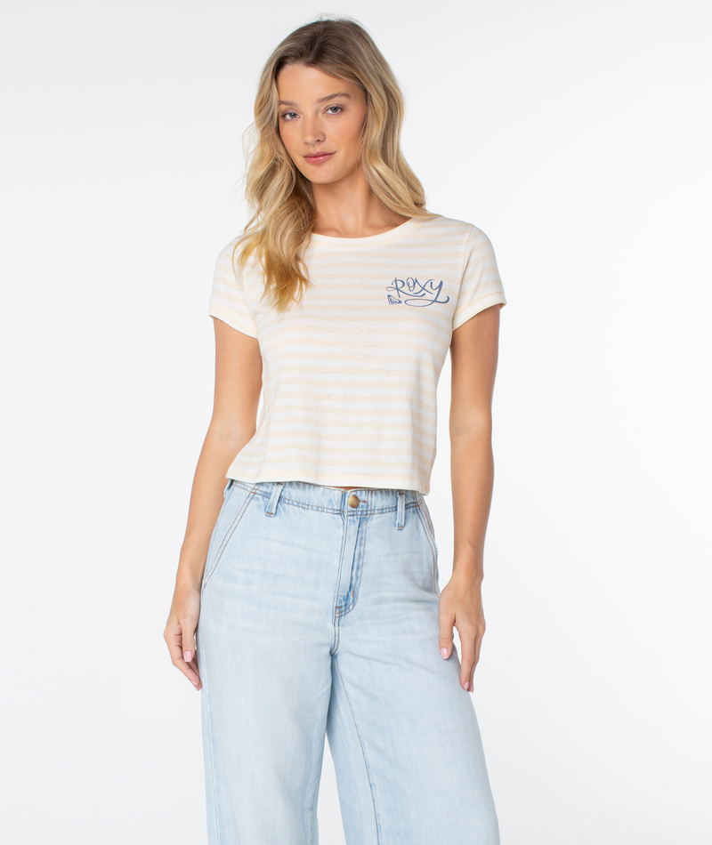 Woman wearing the Vintage Roxy Stripe Top by Roxy, featuring coastal stripes and a chest graphic, paired with high-waisted light blue jeans against a plain white background.
