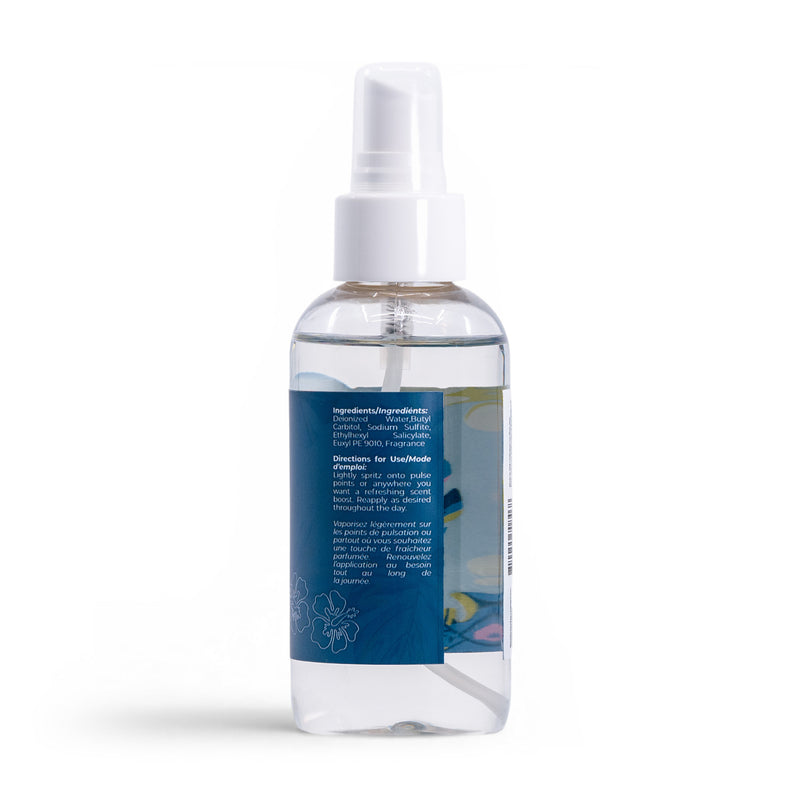 The Roxy Deep Dive Body Mist features a clear spray bottle with a white nozzle and cap, blue label with white text detailing ingredients and directions, and is infused with a refreshing coastal air scent. Transparent liquid shown against a white background.
