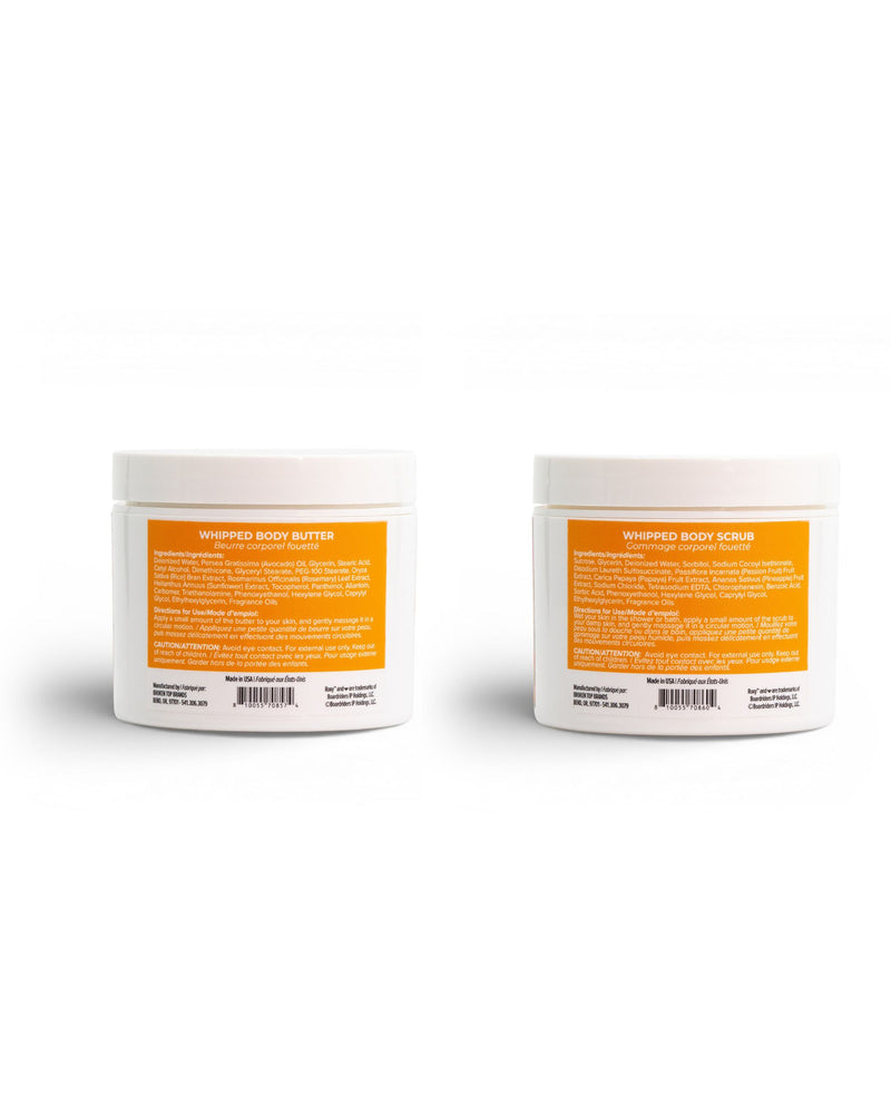 Two white plastic jars with orange labels from ROXY’s Sun Drift Body Butter & Scrub Bundle sit side by side. The left jar is labeled Whipped Body Butter, formulated to hydrate your skin for a silky-soft finish, while the right jar is labeled Whipped Body Scrub, perfect for exfoliating and revealing smooth skin. Both labels feature product information and barcodes.