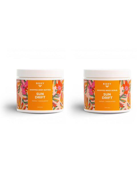 The ROXY Sun Drift Body Butter & Scrub Bundle includes two orange-labeled jars featuring floral designs—one whipped body butter and one whipped body scrub—both infused with tropical notes of papaya and sandalwood to exfoliate, hydrate, and reveal silky-soft skin.